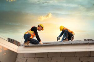 Homeowner inspecting a roof edge from a secured ladder on a clear, dry day.